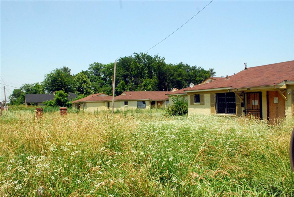 boarded up apartments and weeds